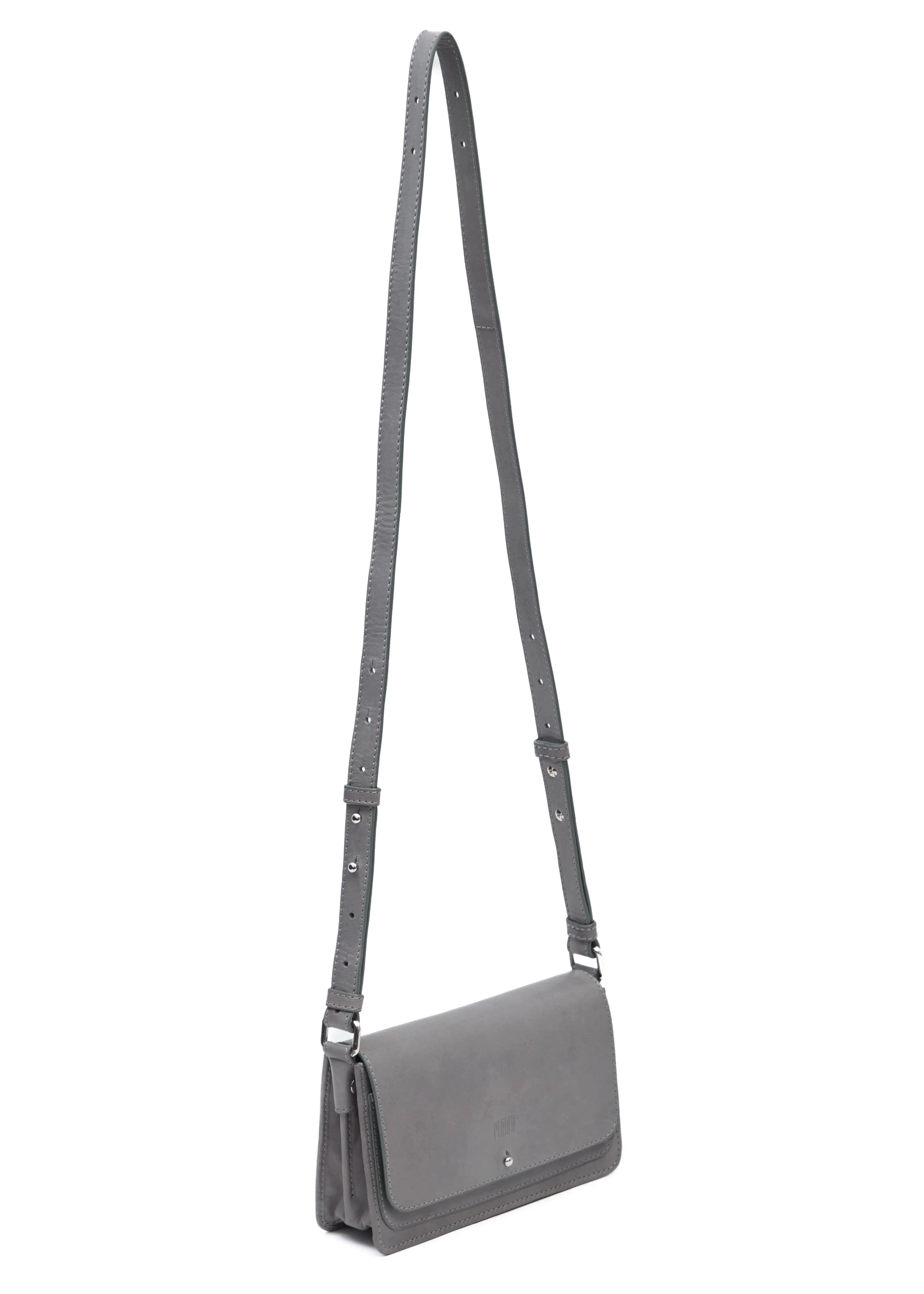 Side view of the Philini Mihaela Wallet Bag in grey Nappa leather, showing softly rectangular shape, front flap with silver cufflink closure, accordion sides, and an adjustable leather strap with silver details. A designer ladies wallet crossbody is functional.